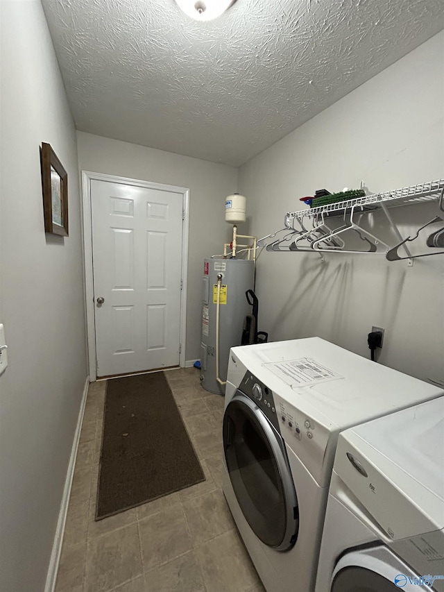 washroom with water heater, washing machine and clothes dryer, and a textured ceiling