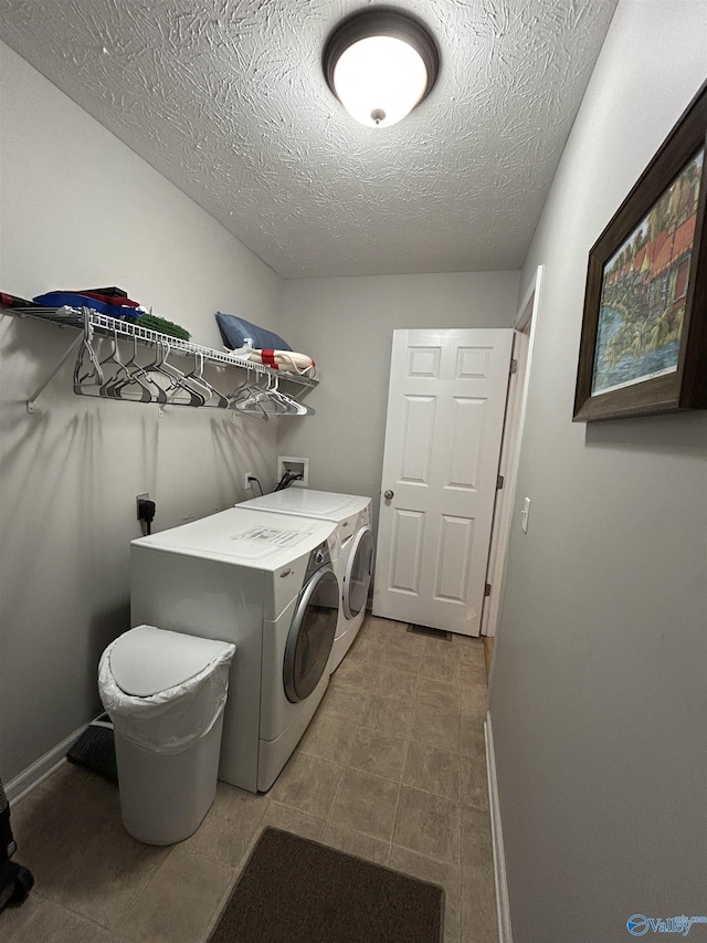 clothes washing area featuring separate washer and dryer and a textured ceiling