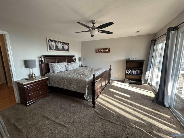 bedroom with ceiling fan and dark colored carpet