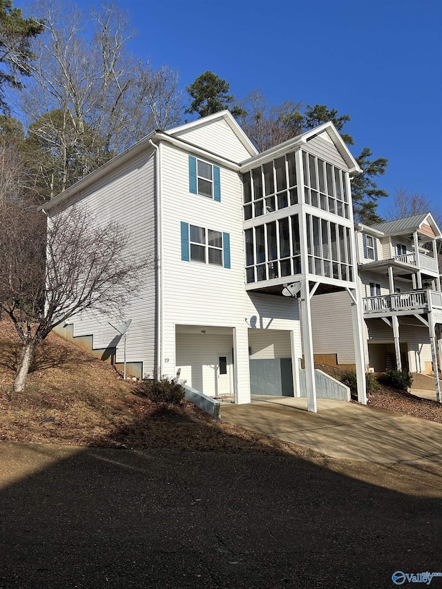 view of front of home with a garage and a sunroom