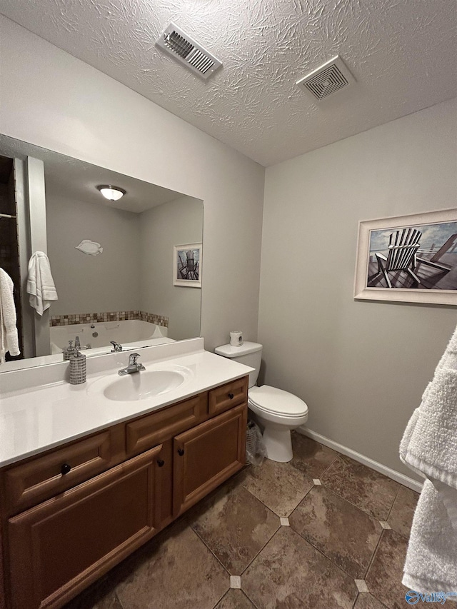 bathroom featuring vanity, a textured ceiling, and toilet