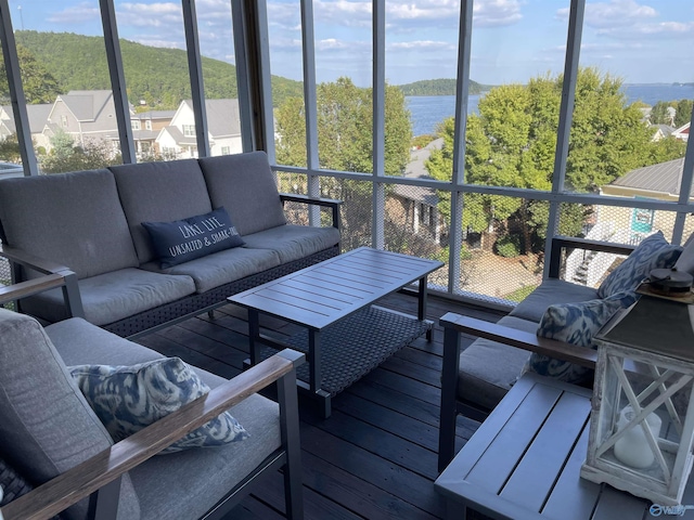 sunroom featuring a water view