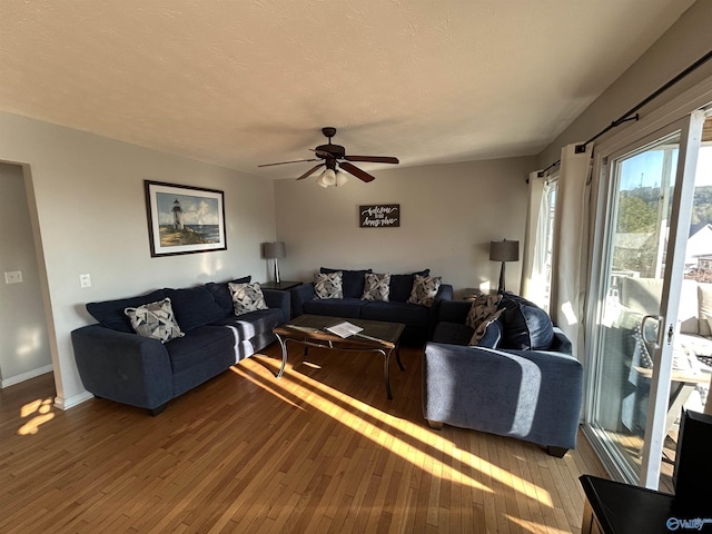 living room featuring ceiling fan, wood-type flooring, and a textured ceiling