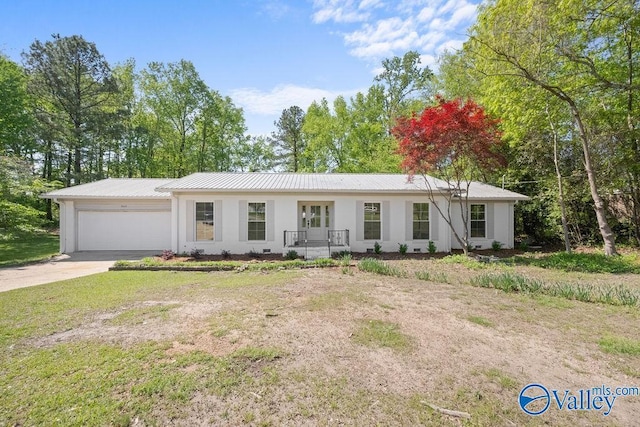 ranch-style home with a garage, driveway, stucco siding, and metal roof