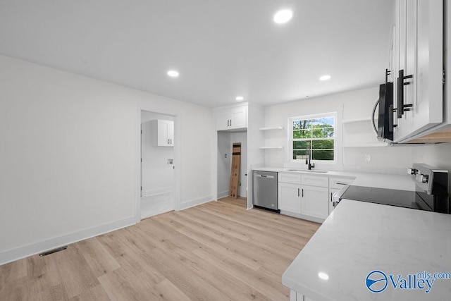 kitchen featuring white cabinets, light wood finished floors, stainless steel appliances, open shelves, and visible vents