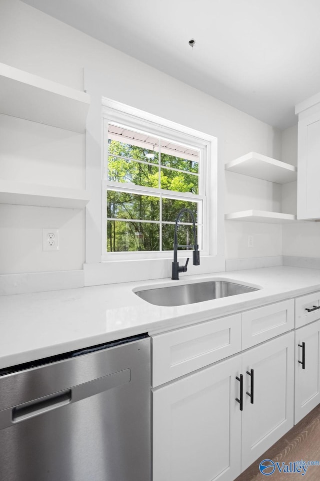 kitchen with open shelves, dishwasher, white cabinetry, and a sink