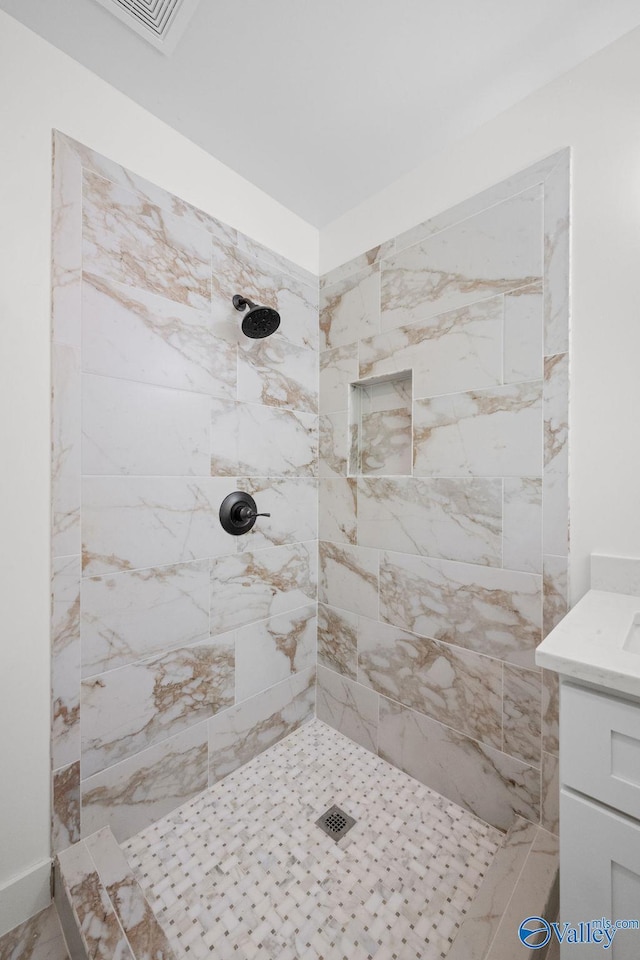 full bath featuring vanity and tiled shower