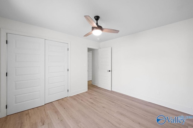 unfurnished bedroom with ceiling fan, baseboards, light wood-style floors, and a closet