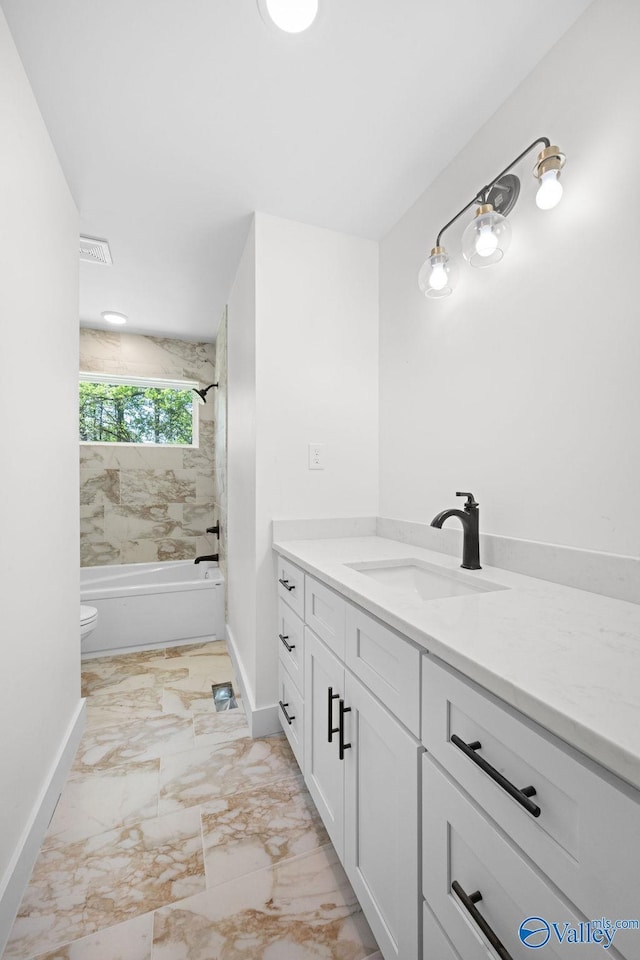 bathroom with washtub / shower combination, vanity, toilet, and baseboards