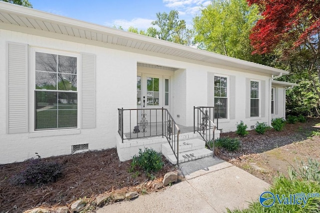 doorway to property with brick siding and crawl space