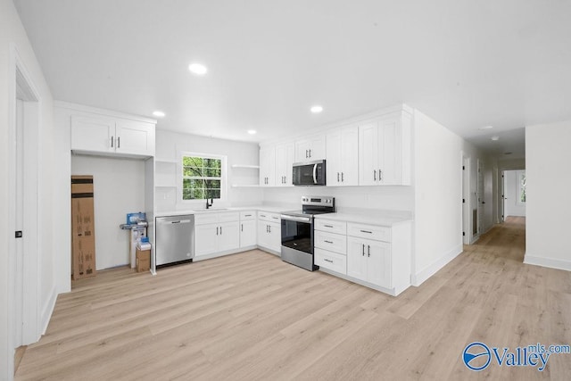 kitchen featuring white cabinetry, stainless steel appliances, light countertops, and light wood-type flooring
