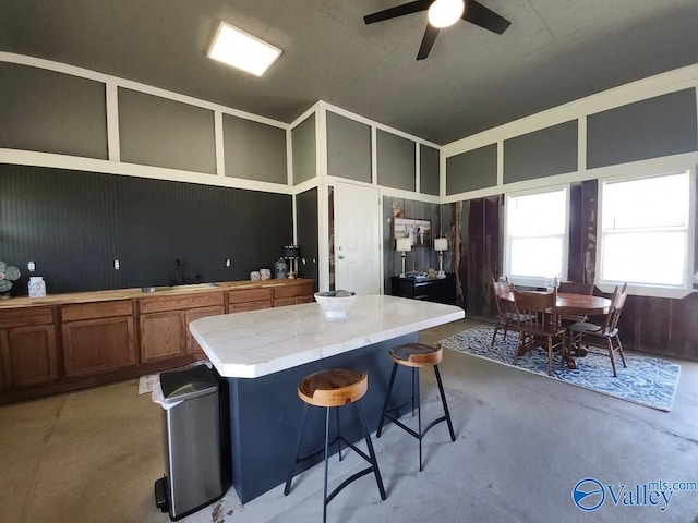 LOT3 County Road 432, Centre, AL 35960 - kitchen with brown cabinetry, concrete floors, a ceiling fan, a kitchen island, and a breakfast bar