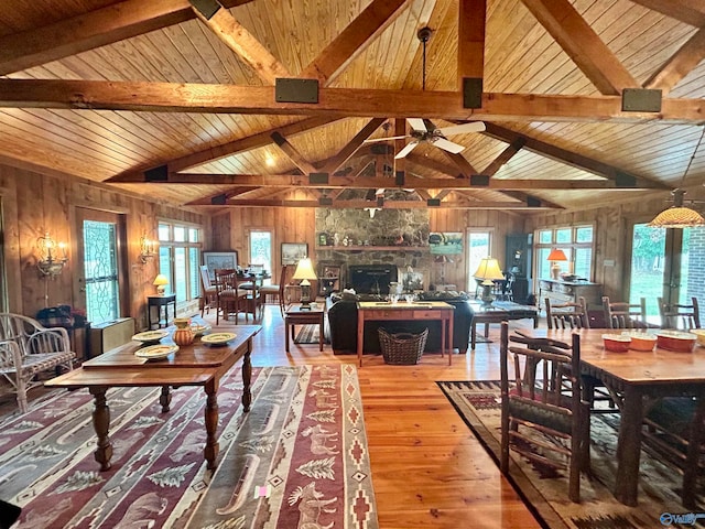 living room with wooden walls, hardwood / wood-style floors, vaulted ceiling with beams, and wood ceiling