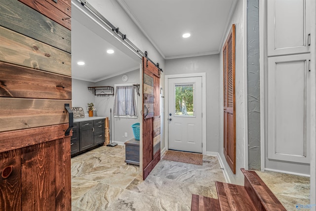 doorway to outside with ornamental molding and a barn door