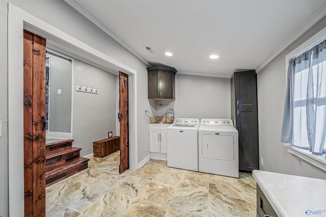 laundry room with sink, washer and dryer, ornamental molding, and cabinets