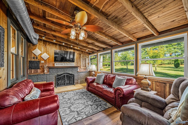 living room featuring hardwood / wood-style floors, ceiling fan, wooden ceiling, beamed ceiling, and wooden walls