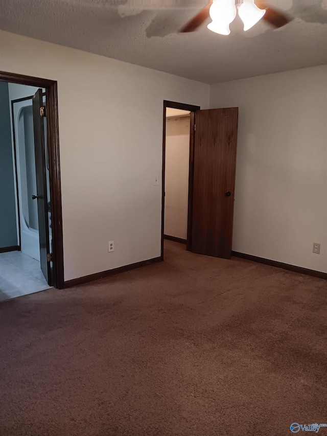 carpeted empty room featuring ceiling fan and a textured ceiling