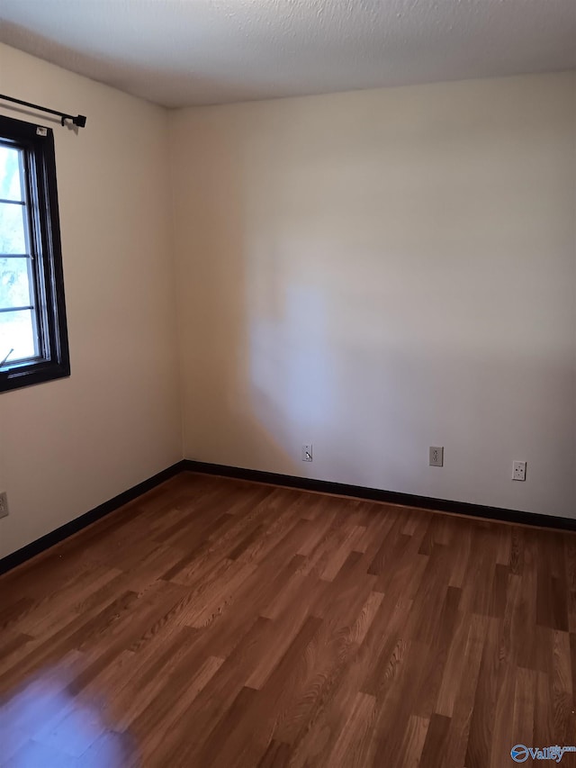 unfurnished room with hardwood / wood-style floors