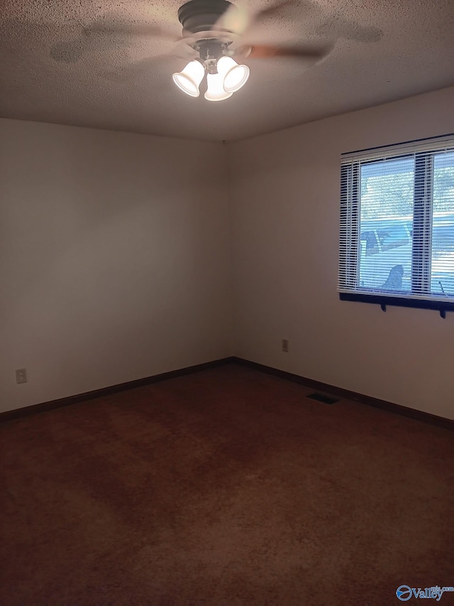 carpeted spare room featuring ceiling fan and a textured ceiling