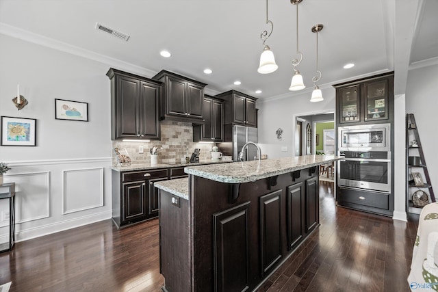 kitchen with crown molding, appliances with stainless steel finishes, dark wood-style floors, and visible vents