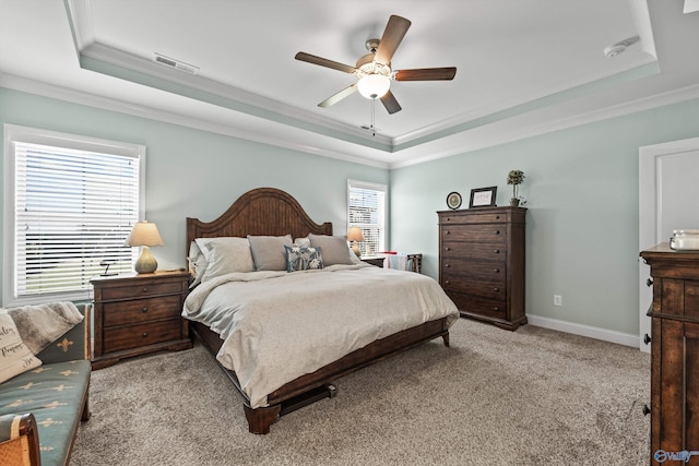 bedroom with ceiling fan, visible vents, a raised ceiling, ornamental molding, and light carpet