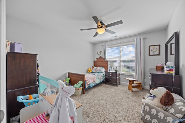 carpeted bedroom with baseboards, a ceiling fan, and visible vents