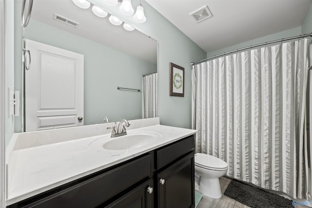 full bath featuring toilet, visible vents, and vanity