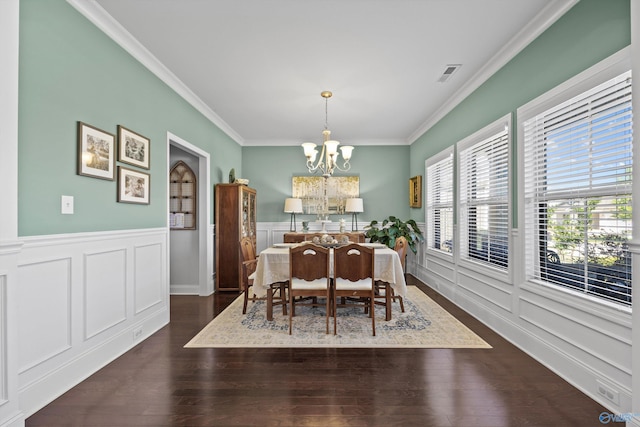 dining space with dark wood-style floors, a chandelier, visible vents, and ornamental molding