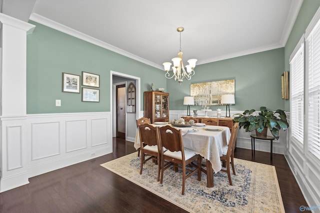 dining area with a wainscoted wall, ornamental molding, dark wood-type flooring, and a chandelier