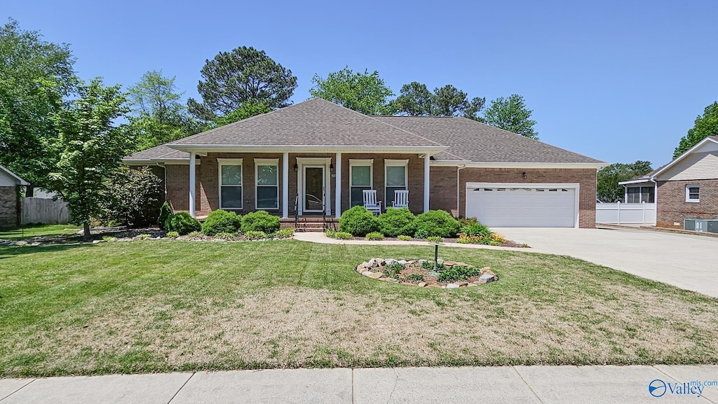 ranch-style home featuring fence, brick siding, concrete driveway, an attached garage, and a porch