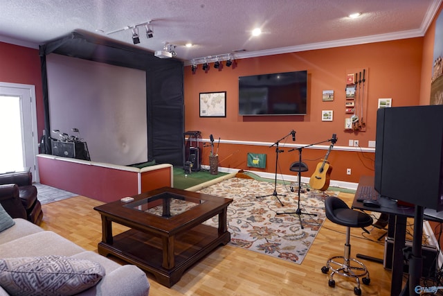game room with track lighting, ornamental molding, wood finished floors, a textured ceiling, and baseboards