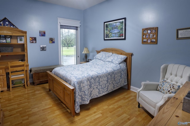 bedroom with access to exterior, light wood-style flooring, and baseboards