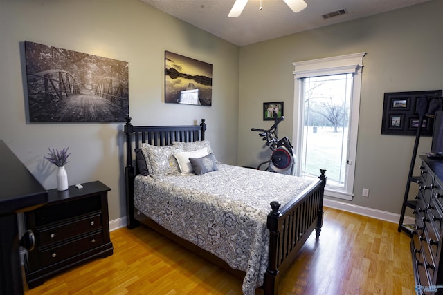 bedroom featuring light wood finished floors, baseboards, and a ceiling fan