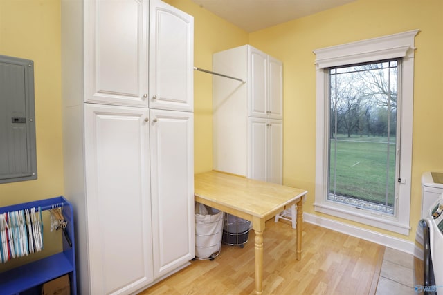 mudroom with electric panel, light wood-style flooring, and baseboards
