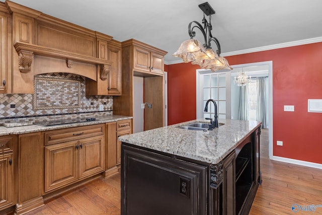 kitchen with brown cabinets, ornamental molding, a sink, wood finished floors, and black electric cooktop