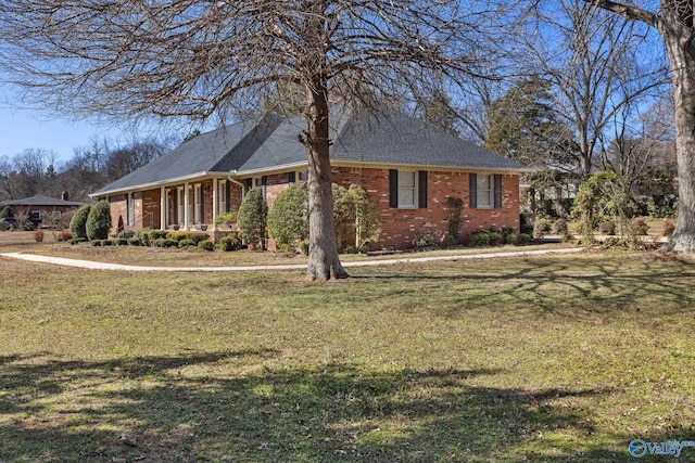 view of front facade with brick siding and a front yard