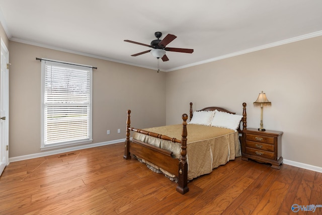 bedroom featuring ornamental molding, baseboards, and wood finished floors