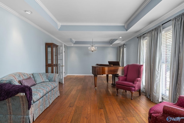 living area featuring baseboards, crown molding, a tray ceiling, and wood-type flooring