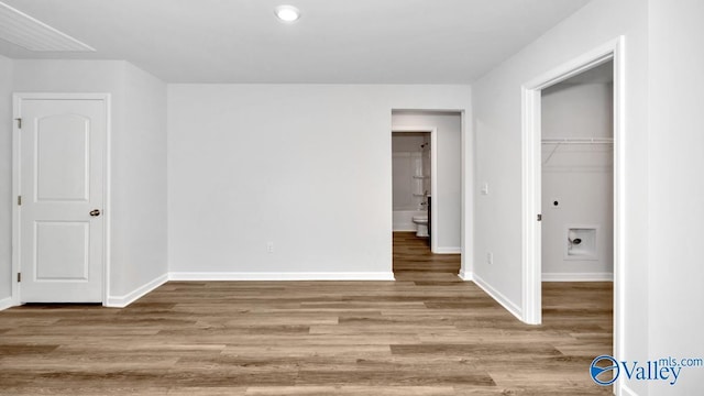 6156 Feather Way SE, Owens Cross Roads, AL 35763 - unfurnished bedroom with baseboards, wood finished floors, a walk in closet, and a closet