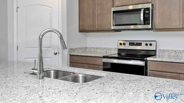 6156 Feather Way SE, Owens Cross Roads, AL 35763 - kitchen featuring stainless steel appliances, a sink, and light stone countertops