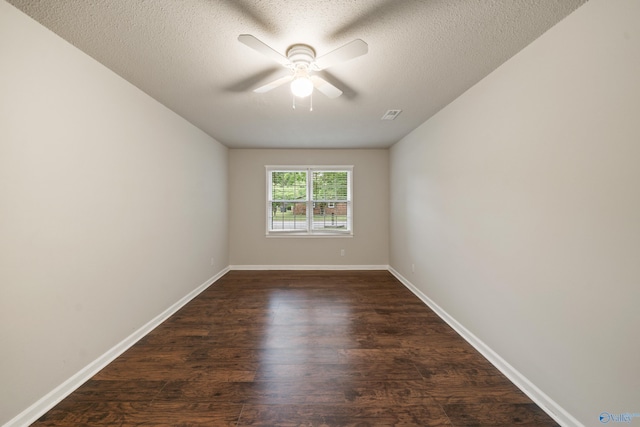spare room with visible vents, baseboards, ceiling fan, a textured ceiling, and dark wood finished floors
