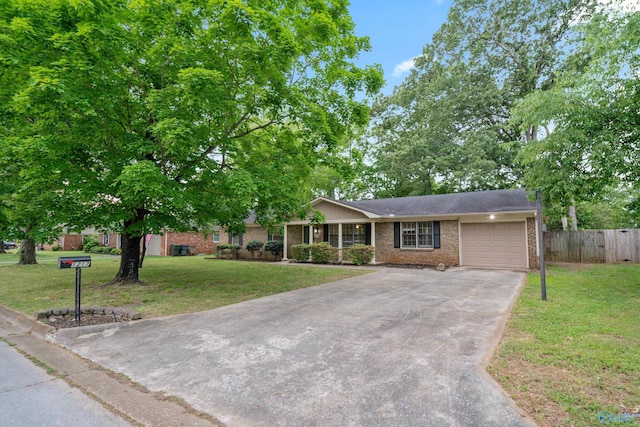 single story home with a garage, a front lawn, fence, brick siding, and driveway