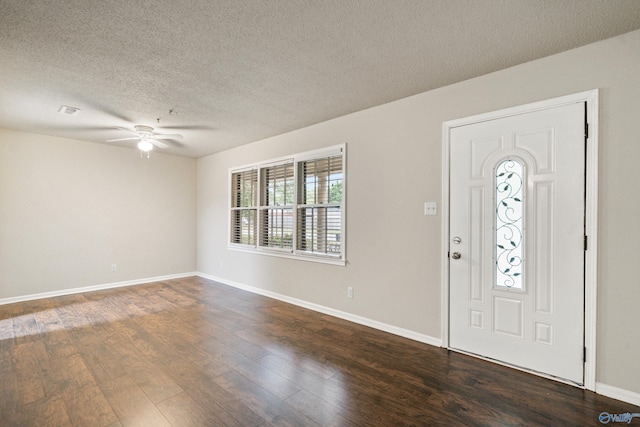 foyer entrance with visible vents, baseboards, dark wood-style floors, a textured ceiling, and a ceiling fan