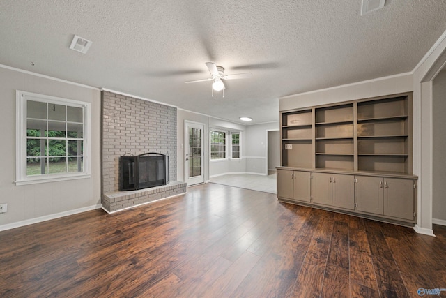 unfurnished living room with crown molding, ceiling fan, dark wood finished floors, and a textured ceiling