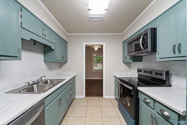 kitchen with backsplash, a textured ceiling, visible vents, a sink, and stainless steel appliances