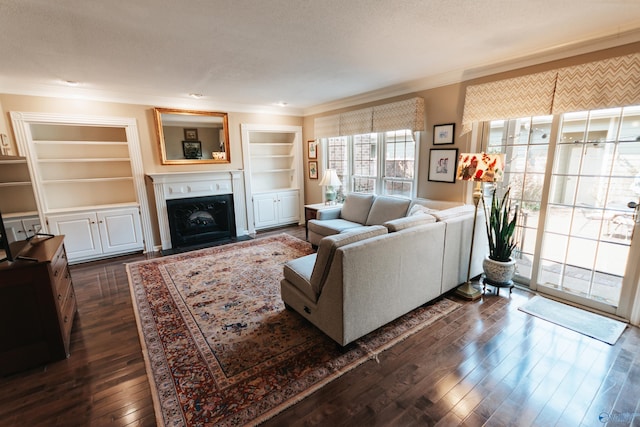 235 Inverness Dr Unit 235, Huntsville, AL 35802 - living room featuring a textured ceiling, built in shelves, a fireplace with flush hearth, dark wood-style floors, and crown molding