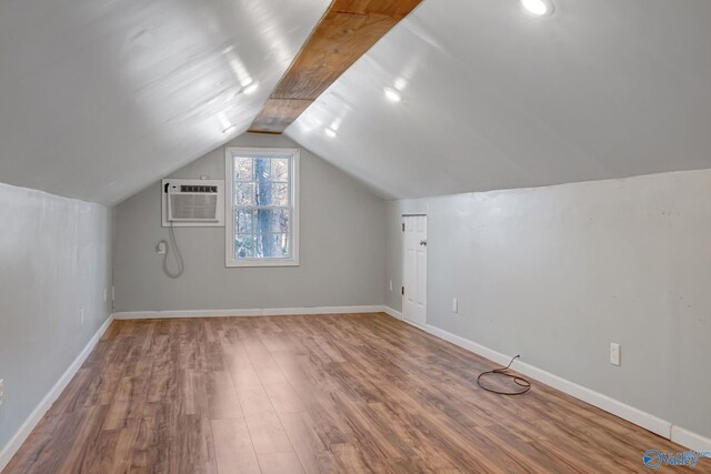 bonus room featuring hardwood / wood-style flooring, lofted ceiling, and a wall unit AC