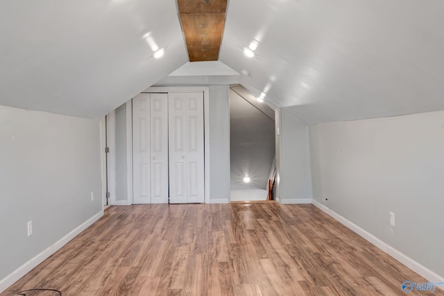 bonus room with wood-type flooring and vaulted ceiling