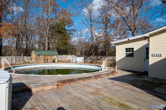 view of pool with a wooden deck and a shed