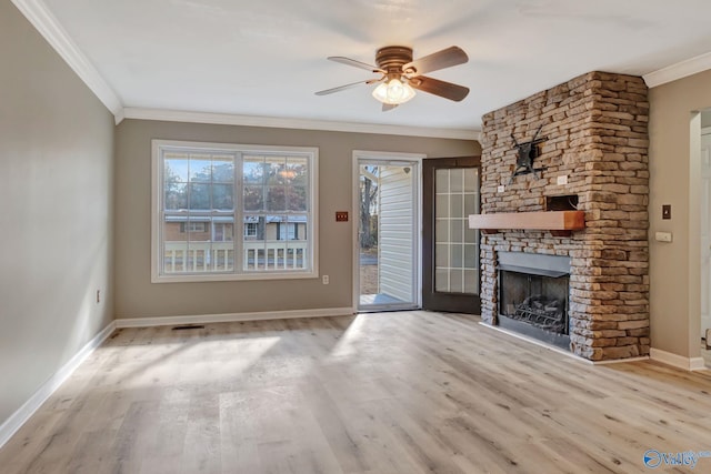 unfurnished living room with a stone fireplace, crown molding, ceiling fan, and light hardwood / wood-style floors